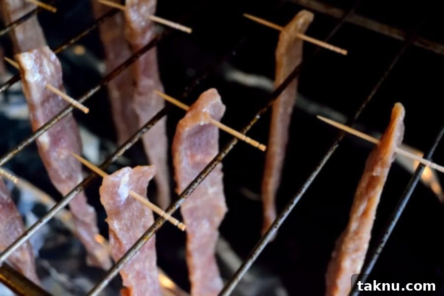 Brown Sugar Jerky strips hanging in an oven to dehydrate.