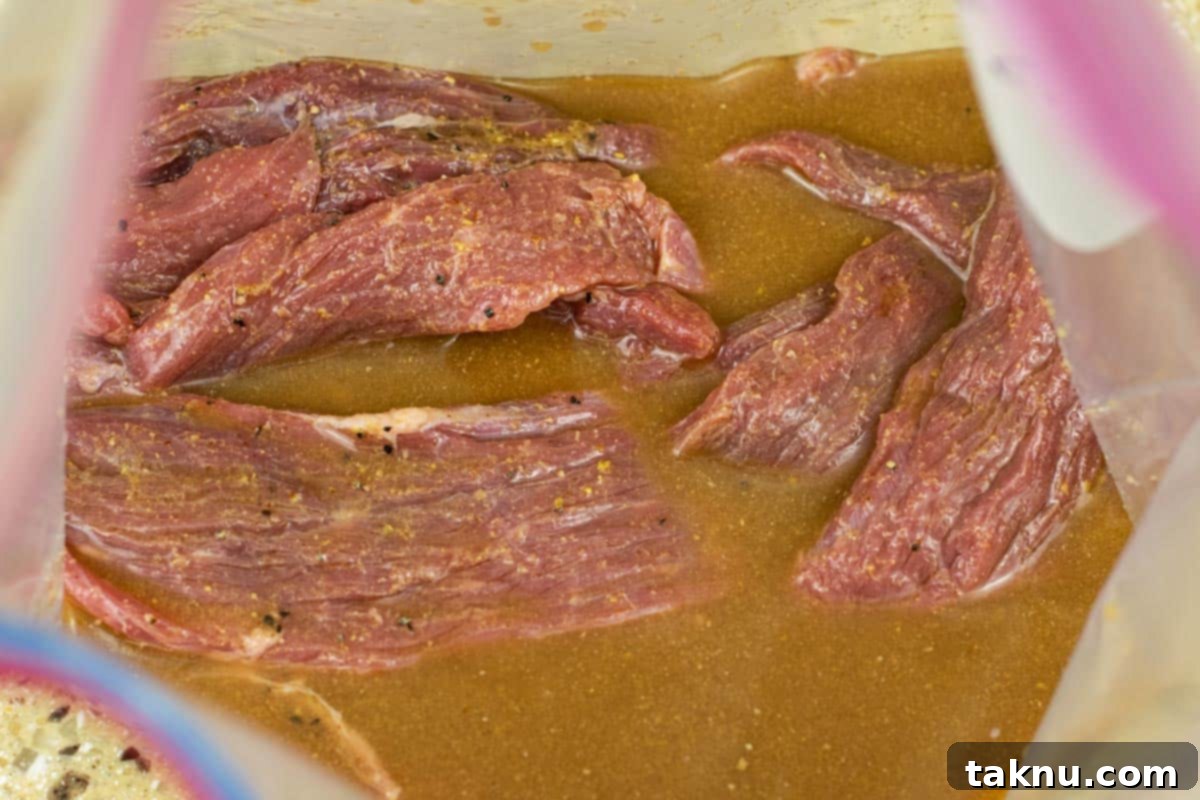 Zesty Beef Jerky 5 Beef jerky marinating in a tangy marinade in a ziplock bag