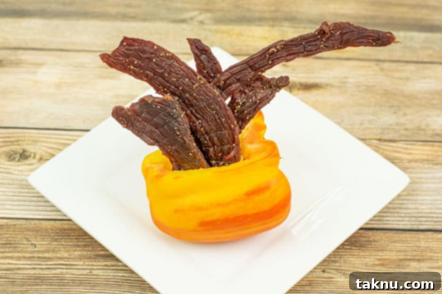 Zesty Beef Jerky 8 Tangy flavored beef jerky in orange bell pepper on plate, ready to be enjoyed