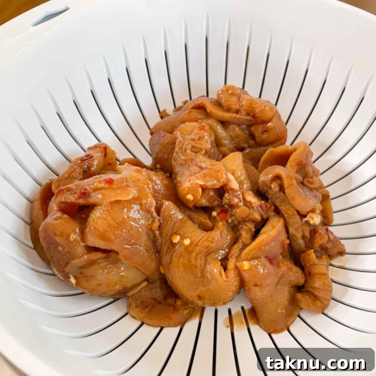 Chicken Jerky 6 marinated chicken strips straining in colander