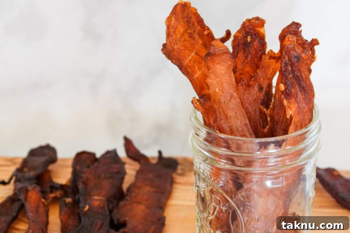 Chicken Jerky 9 Chicken jerky in mason jar on cutting board with marble background