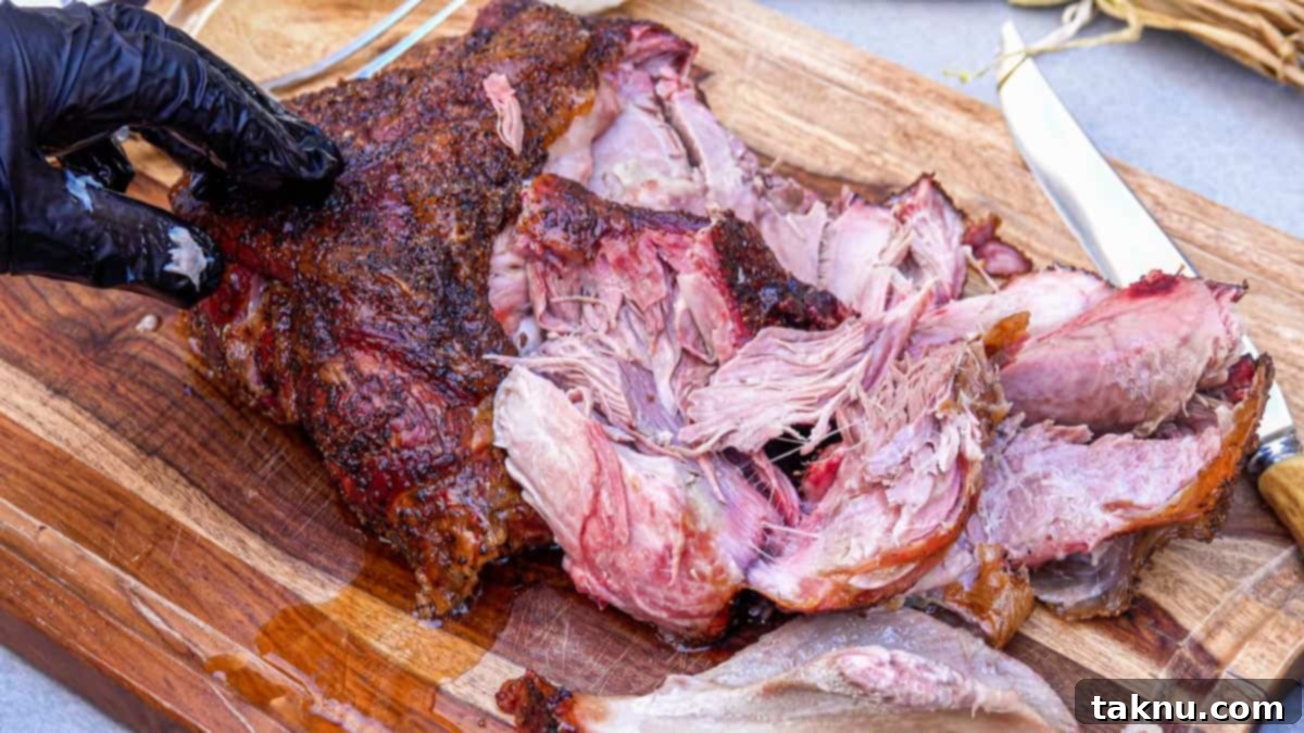 Fall-Apart Smoked Pork Butt 6 Shredded smoked pork shoulder on cutting board, ready to be served or used in various dishes.