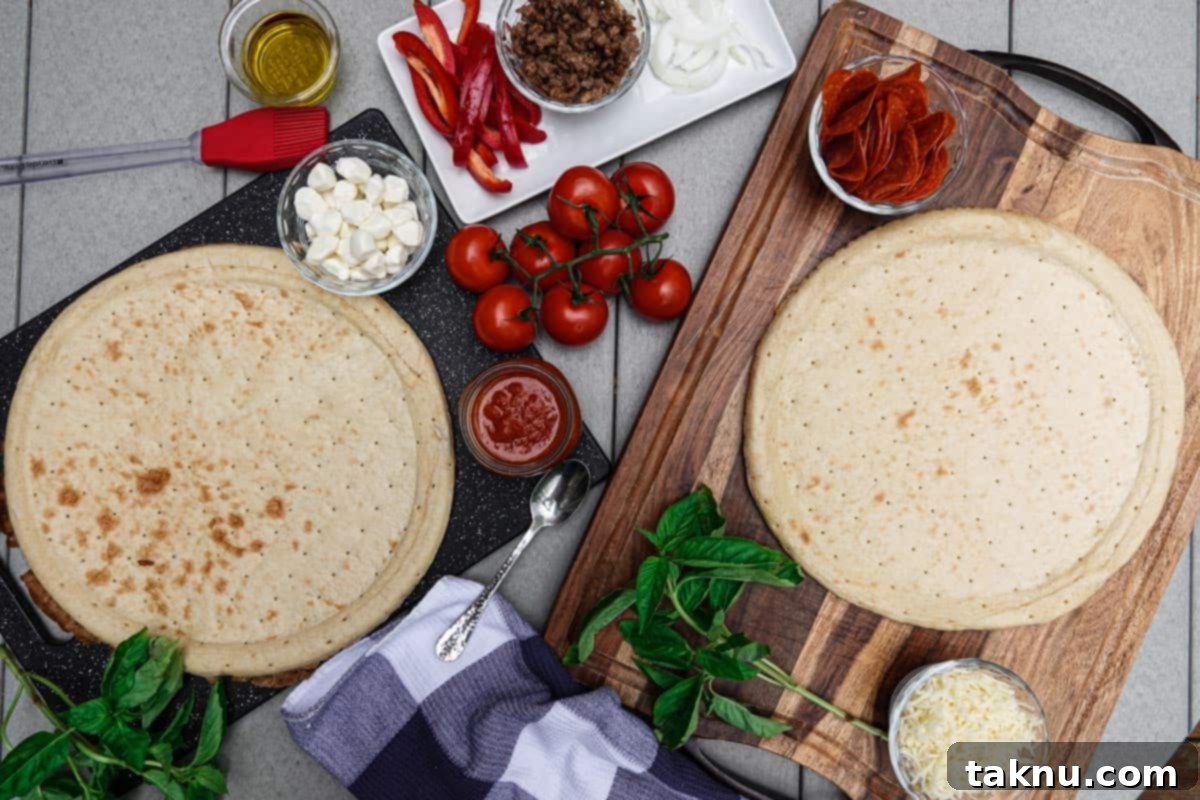 Smoky Cheesy Pizza Thirty Topping Inspirations 3 Pizza crust, ready to be topped, with fresh ingredients like basil, tomatoes, and various cheeses artfully arranged around it.