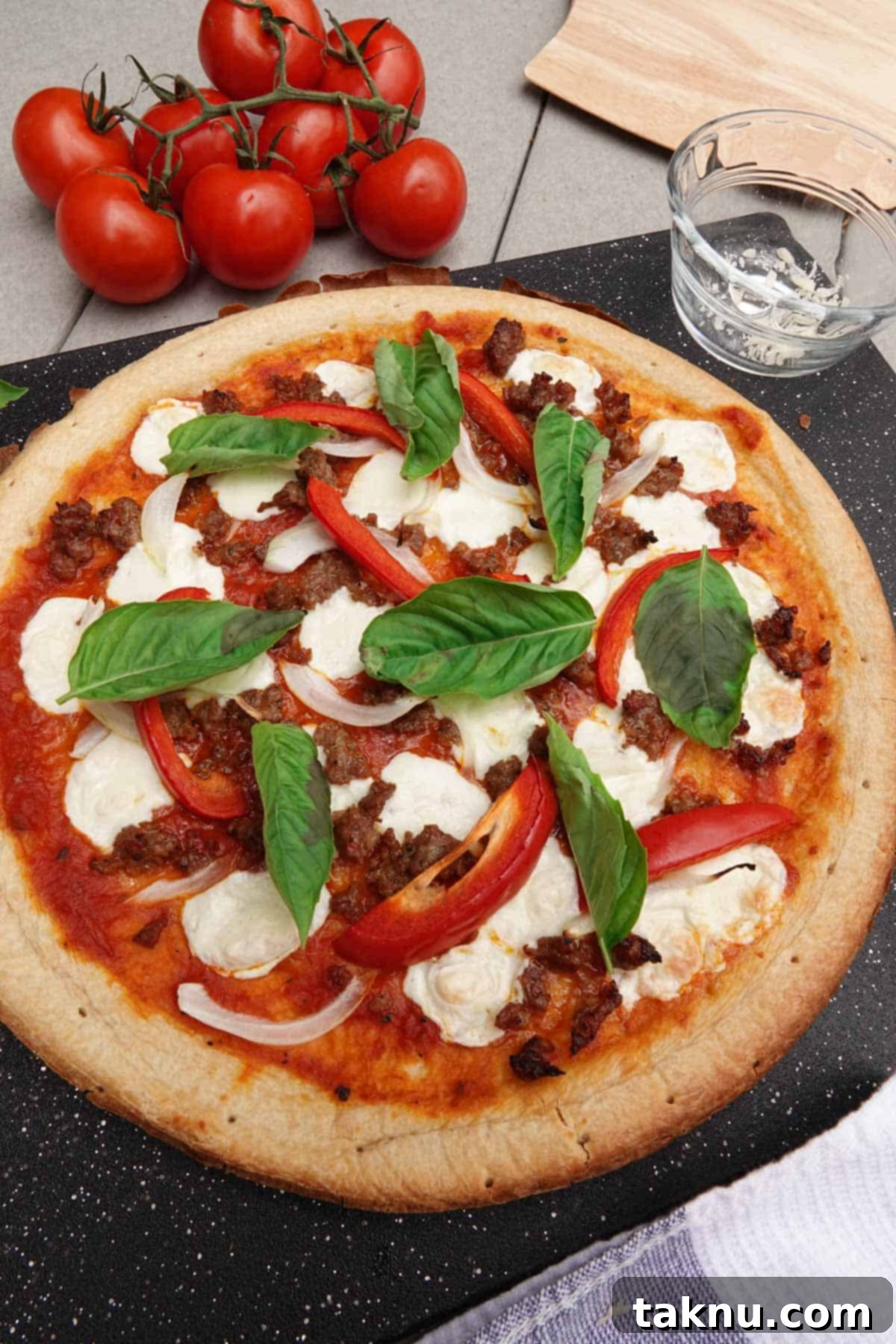 Smoky Cheesy Pizza Thirty Topping Inspirations 10 A perfectly cooked smoked pizza resting on a cutting board, garnished with fresh basil, beside a vine of ripe red tomatoes, emphasizing freshness and quality.