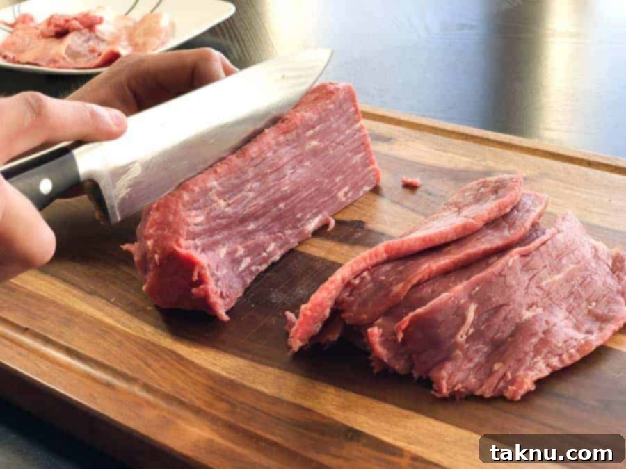Dr Pepper Beef Jerky 4 Eye of round beef roast being sliced in cutting board