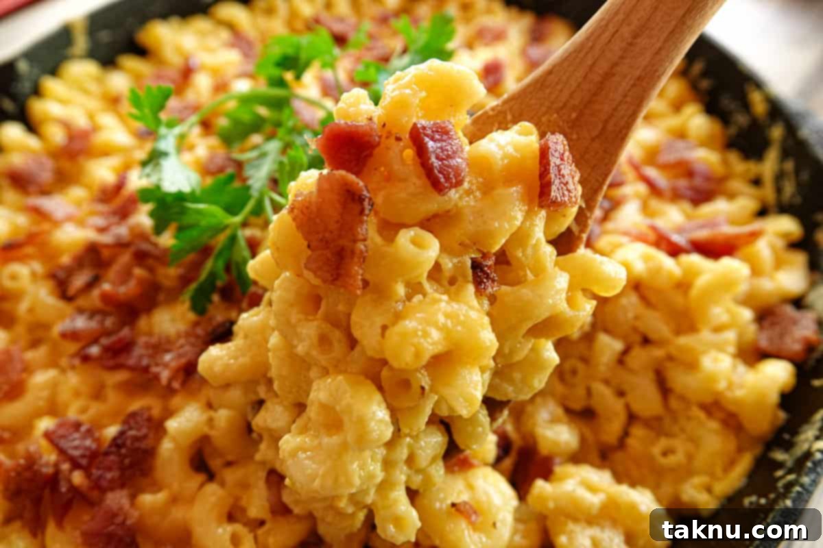 Ultimate Smoked Mac and Cheese 7 mac and cheese being spooned out of cast iron skillet