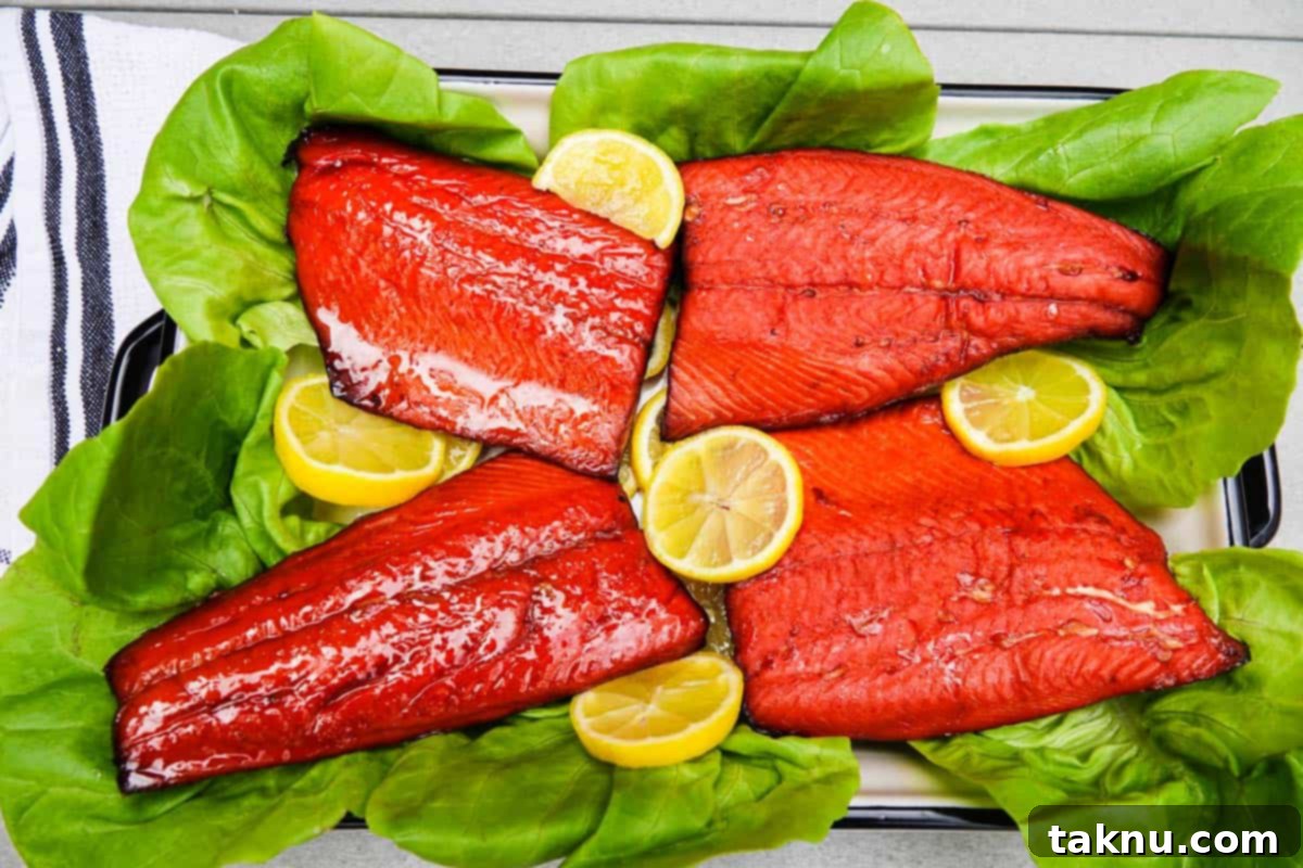 Beautifully smoked salmon fillets served on a bed of fresh lettuce with lemon slices, ready to eat