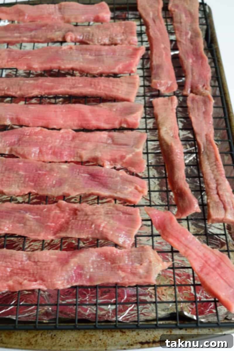 Tropical Mai Tai Beef Jerky 5 Mai Tai Beef Jerky strips drying on a cooling rack in the oven