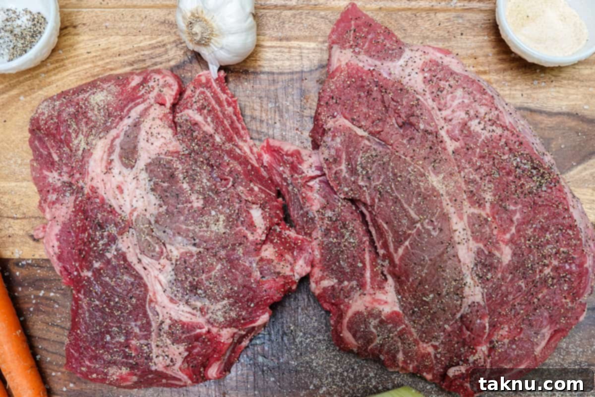 A 4lb chuck roast liberally seasoned with salt and pepper on a cutting board, ready for the smoker.