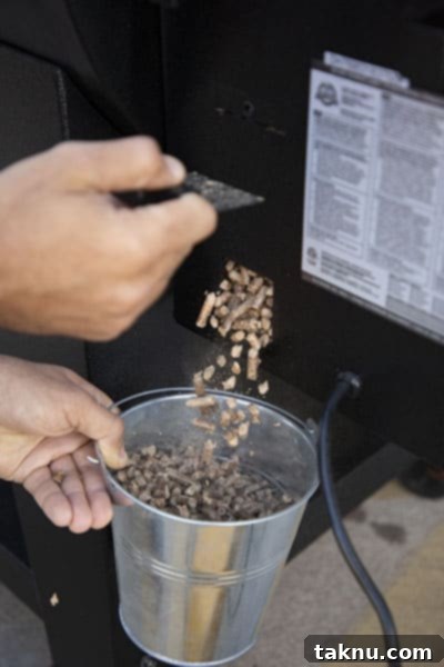 Best Pellet Smokers of 2025 Your Ultimate Buyers Guide 10 pellet hopper being cleaned out by flowing into bucket