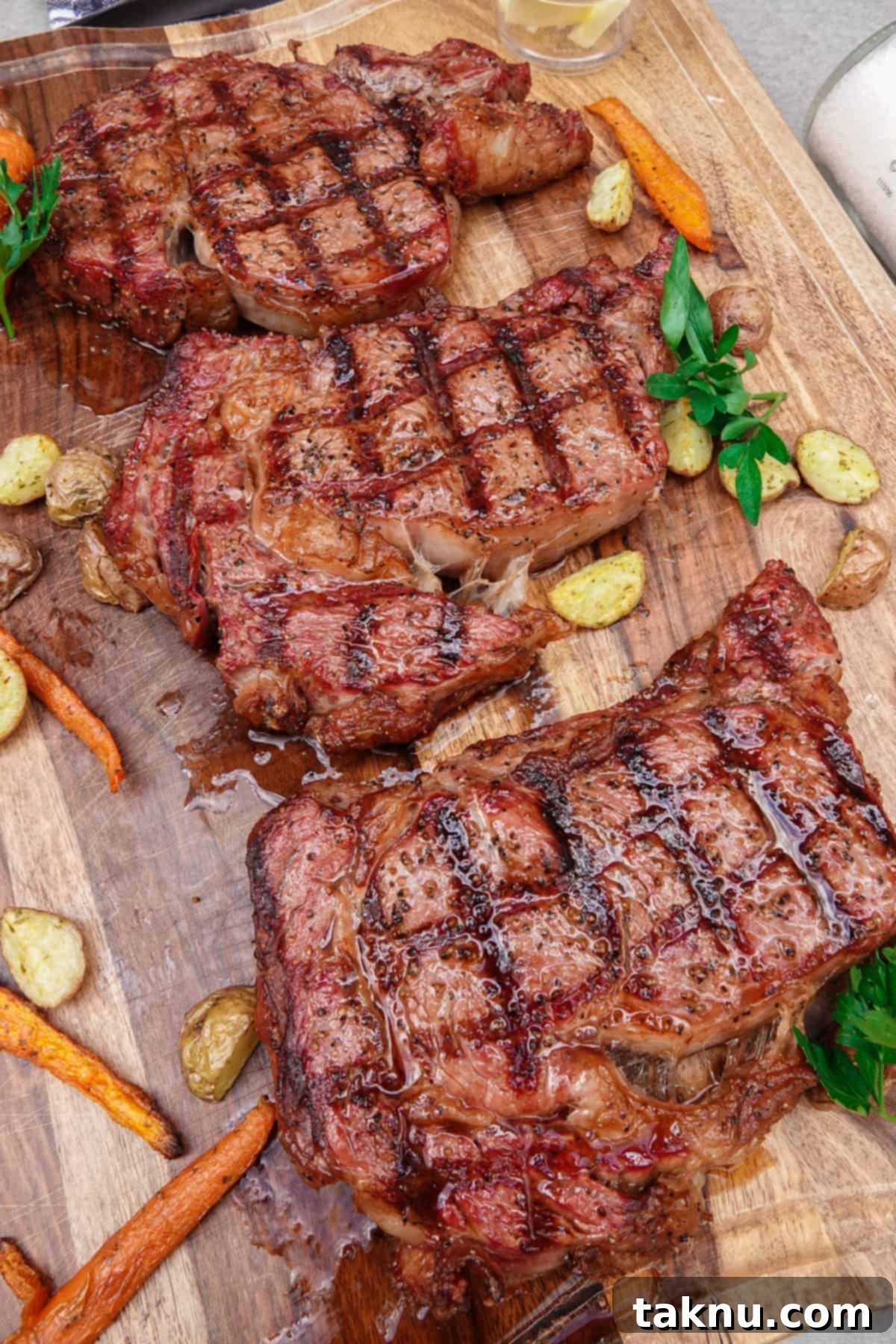 Ultimate Smoked Ribeye 8 Three perfectly cooked, sliced ribeye steaks presented on a wooden cutting board, showcasing a beautiful medium-rare interior.